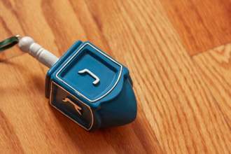 close up of blue hanukkah dreidel on a wood background