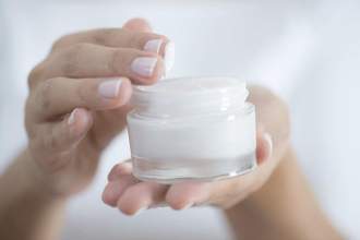 close up of hands holding a lotion container