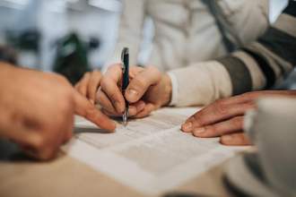 close up of person signing a contract
