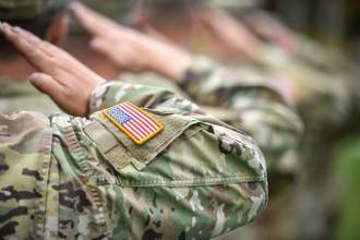 close up shot where a line of uniformed soldiers are saluting