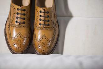 closeup of tanned brogue derby shoes made of calf leather with rubber sole