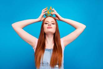 confident woman holding a crown over her head
