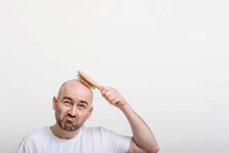 confused man trying to brush his bald head