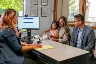 couple and their young daughter speaking to a bank associate