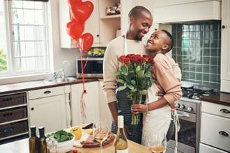 couple looking lovingly in each others eyes while standing in the kitchen