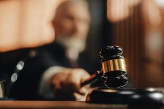 court judge slamming a gavalin on a form to the from right of the screen with a judge blurry in the background