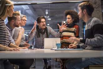 coworkers frightened by their angry boss whose yelling at them in a meeting