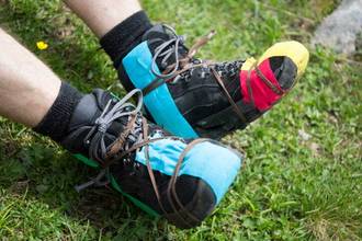 damaged climbing shoes repaired with tape and string