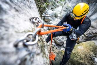downward view of a person rock climbing on the side of a mountain