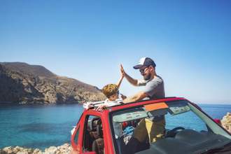father and son giving each other a high five after making their drive to the beach