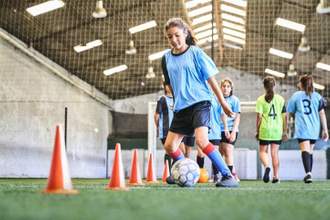 female soccer player practicing skills at court