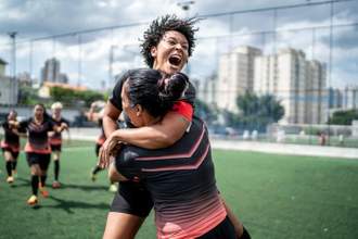 female soccer team celebrating at the end of a game
