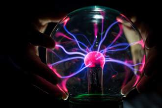 fingers touching plasma ball