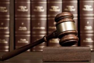 gavel on wooden desk with books as background