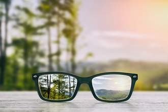 glasses in focus with blurry landscape in background