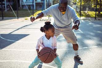 grandfather and granddaughter playing basketball