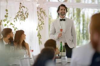 groomsman standing to make a toast to the bride and groom