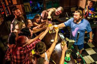 group cheering their drinks at the bar