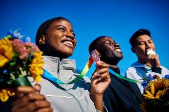group of athletes with medals and bouquets celebrating their victories
