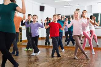 group of children learning how to dance