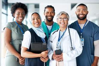 group of nurses and doctors standing together smiling