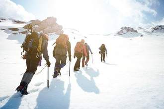 group of people on an expedition up a snowy mountain