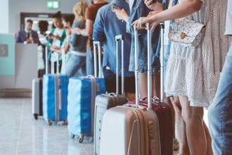 group of people with their suitcases waiting in line at the airport