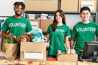 group of young volunteers smiling happy working at charity center