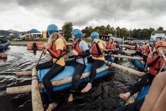 group paddling a raft
