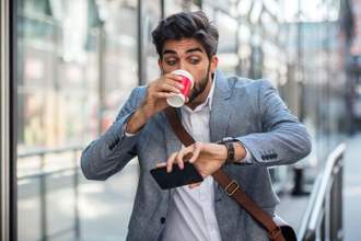 guy looking at his watch startled by how late he is to work