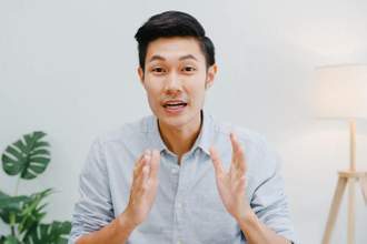 guy looking at the audience hands stretched out while talking