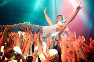 guy looking super excited as he crowd surfs at a rock concert