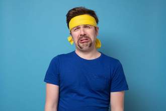 guy with a yellow bandana looking miserably at the camera