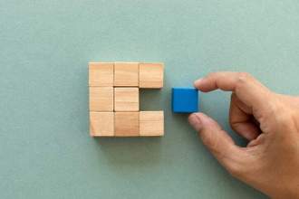 hand pulling out a blue square from a larger square block