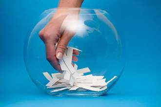 hand pulling scrap of paper from bowl