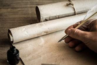 hand writing with old quill pen on the old paper