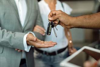 handing over a pair of keys to new owner