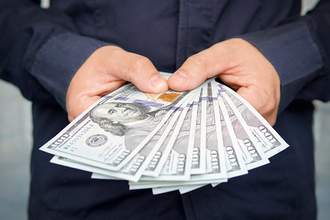 hands fanning out hundred dollar bills