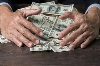 hands gathering a pile of bills