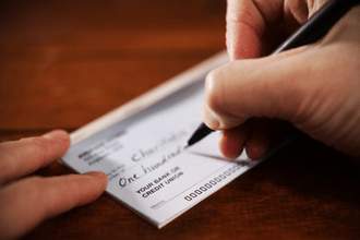 hands writing a cheque