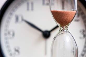 hourglass in front of clock