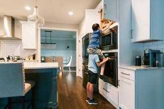 kid carrying friend on shoulders trying to get into upper pantry