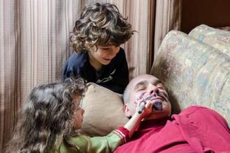 kids drawing on sleeping adults face