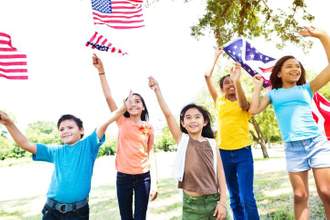 kids running around waving american flags