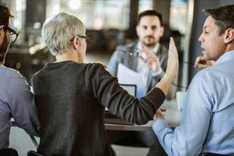 lady holding her hand up to stop a coworker from speaking