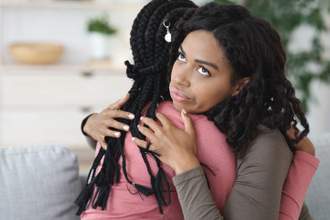 lady looking irritated while hugging her friend