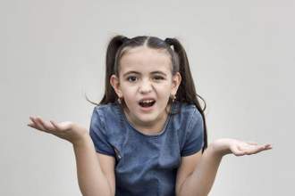 little girl shrugging her shoulders looking absolutely confused at the camera