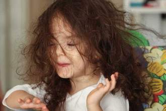 little girl with disheveled hair in her face
