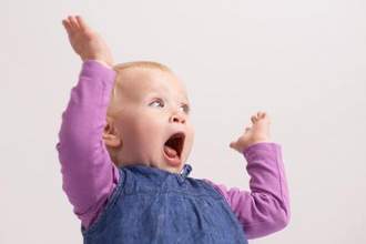 little girl with her hands in the air really excited about something