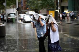 man and woman caught in the rain using newspaper as an umbrella